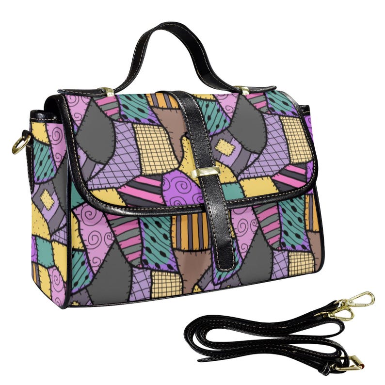 May include: A satchel-style handbag with a patchwork design in various colors, including purple, yellow, and green. The bag has a black handle, a black strap, and a black flap with a gold-colored clasp. The bag's design is reminiscent of a quilt.