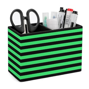 Puede incluir: Un organizador de escritorio a rayas negras y verdes con cuatro compartimentos. El organizador contiene un par de tijeras, marcadores y bolígrafos.