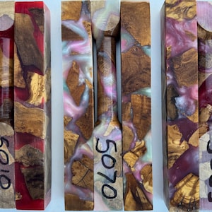 May include: Three rectangular blocks made of natural wood burl and colored resin. The left block features red resin, the center has pink and white swirls, and the right has purple and white swirls. Each block is marked with numbers 5019, 5070, and 5055.