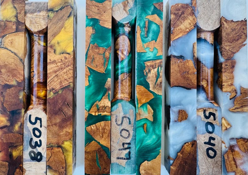 May include: Three rectangular pen blanks made of natural wood burl pieces encased in colored resin. The left blank features yellow resin, the center features green resin, and the right features white resin. Each blank is marked with numbers 5038, 5047, and 5040.