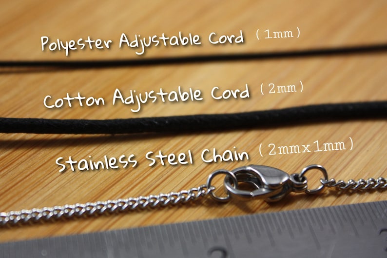 May include: Close-up of three different types of necklace cords: polyester adjustable cord (1mm), cotton adjustable cord (2mm), and stainless steel chain (2mm x 1mm).