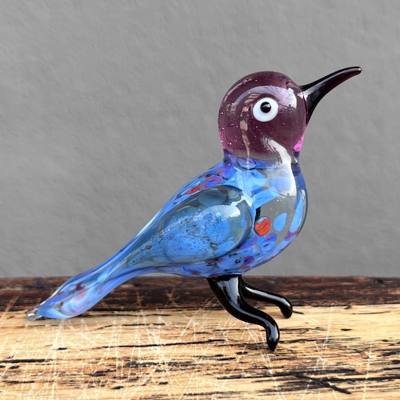 Delicate hand-blown glass bird sculpture where color and form are shaped entirely by the glassblower's breath — no two are identical.