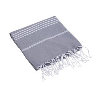Op de afbeelding: Een gevouwen grijze handdoek met een reeks dunne witte horizontale strepen aan de bovenzijde. De stof heeft een geweven textuur en is afgewerkt met lange, witte, gedraaide franjes langs de onderrand van het textiel.