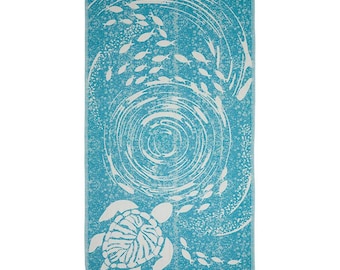 May include: A turquoise beach towel with a white design of a sea turtle and fish swimming in a swirling pattern.
