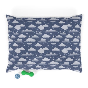 May include: A blue and white pet bed with a cloud and star pattern. The bed is filled with soft, plush material and is perfect for a small dog or cat.