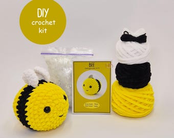 Peut inclure: Un kit de crochet DIY pour un amigurumi abeille. Le kit comprend du fil jaune, noir et blanc, un petit sac de rembourrage et une carte jaune avec une illustration d'abeille. L'abeille finie est jaune et noire avec des ailes blanches.