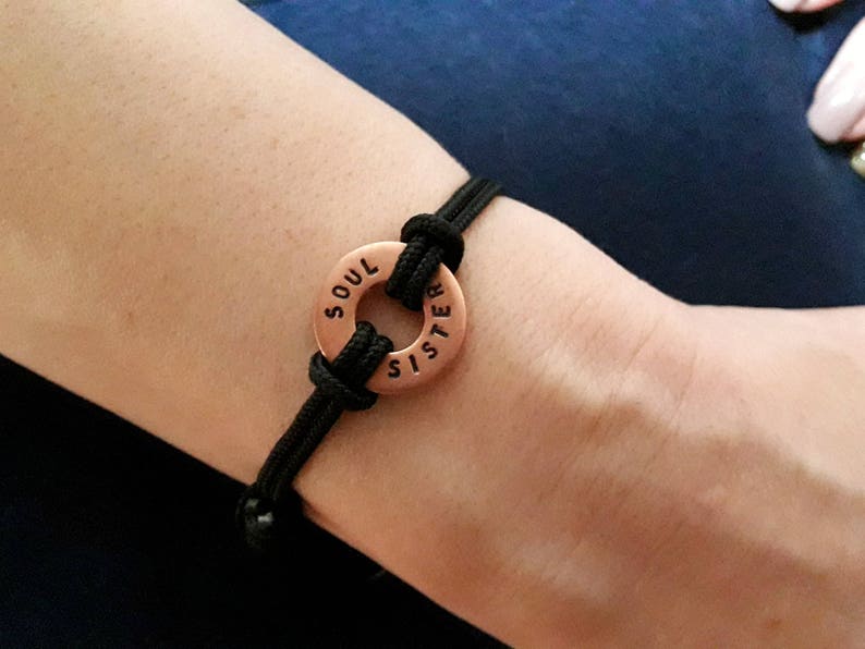 May include: A black cord bracelet with a copper charm that reads "Soul Sister".