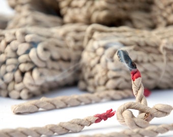 May include: Close-up of several brown firecrackers with lit fuses and smoke. The fuses are red and white, and some are already burned. The firecrackers are on a white background.