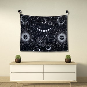 Black and white zodiac moon phase tapestry displayed above a dresser, featuring constellation details and celestial sun moon artwork.