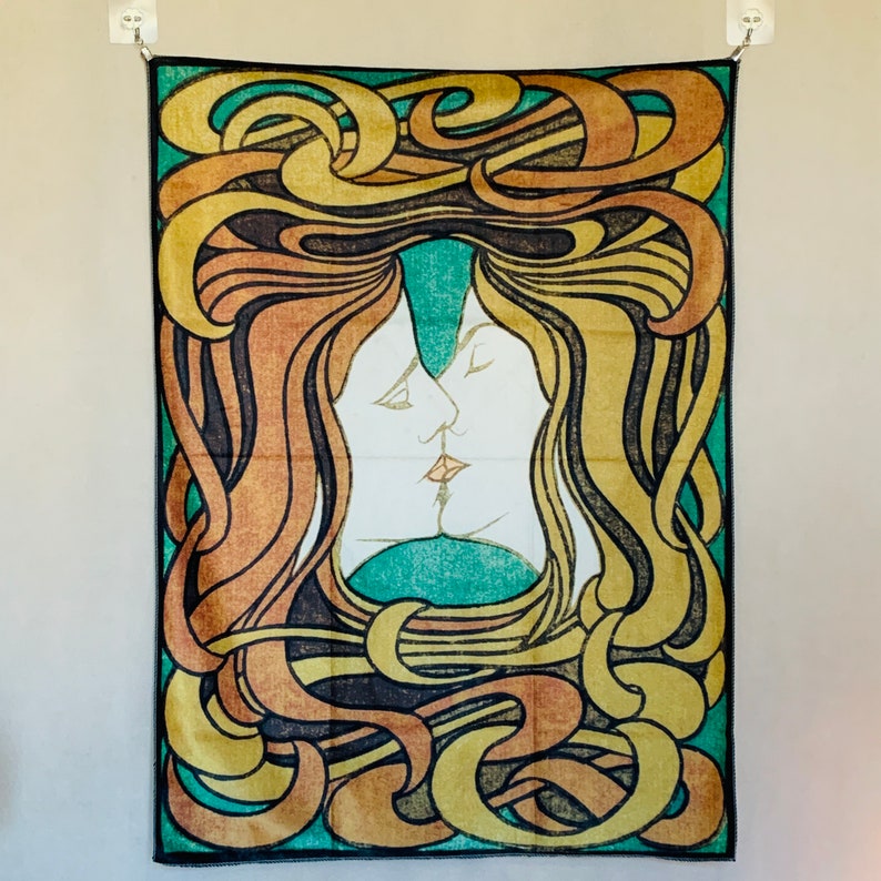 Front view of Peter Behrens The Kiss wall tapestry with intertwined profiles and sweeping yellow, orange, green and black linework.