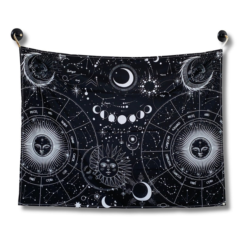Front view of black and white celestial zodiac tapestry featuring moon phases, constellations, star charts, and vintage style sun moon faces.