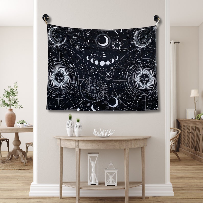 Black and white celestial tapestry displayed above a console table, with zodiac symbols, moon phases, constellations, and sun moon artwork.