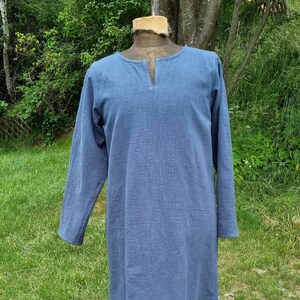 May include: A long-sleeved, light blue tunic with a V-neck.