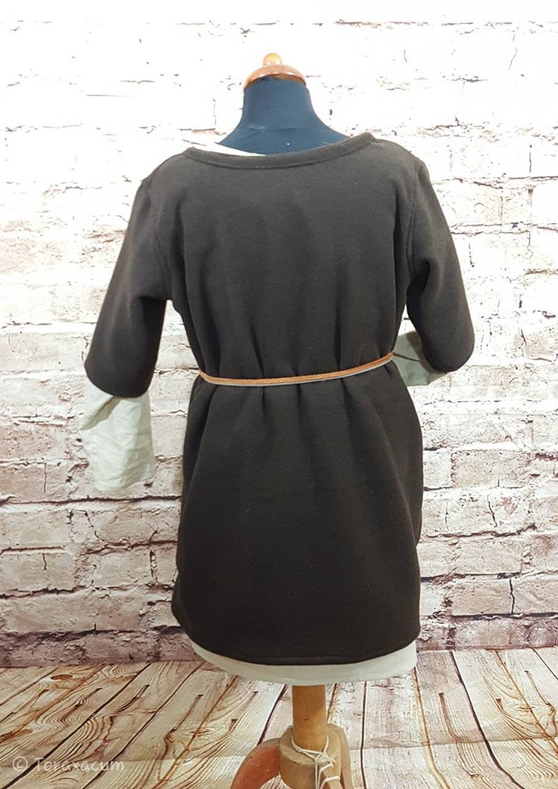 May include: A brown long-sleeved dress with a beige under layer. The dress has a brown belt around the waist.