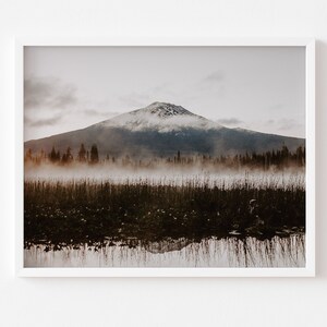 A framed photograph of Mt. Bachelor at sunrise with trees and fog in the foreground