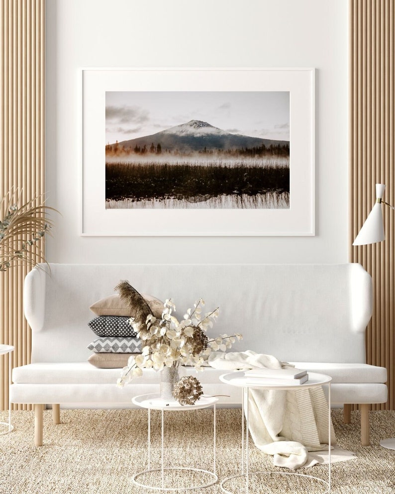 A framed photograph of Mt. Bachelor at sunrise with trees and fog in the foreground