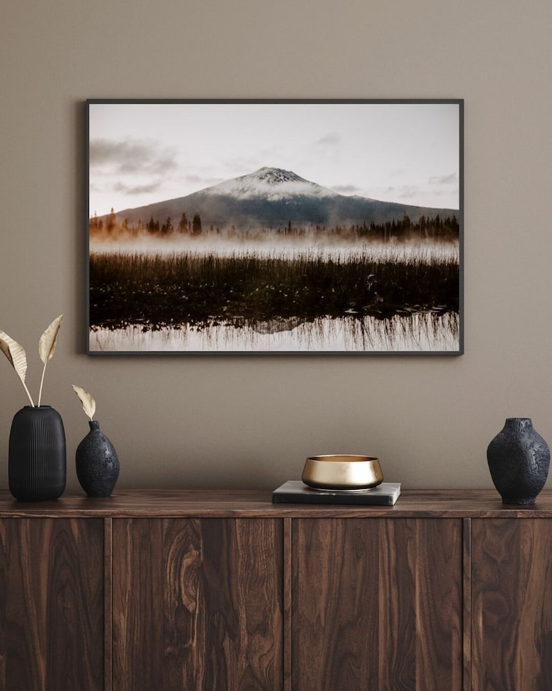 A framed photograph of Mt. Bachelor at sunrise with trees and fog in the foreground