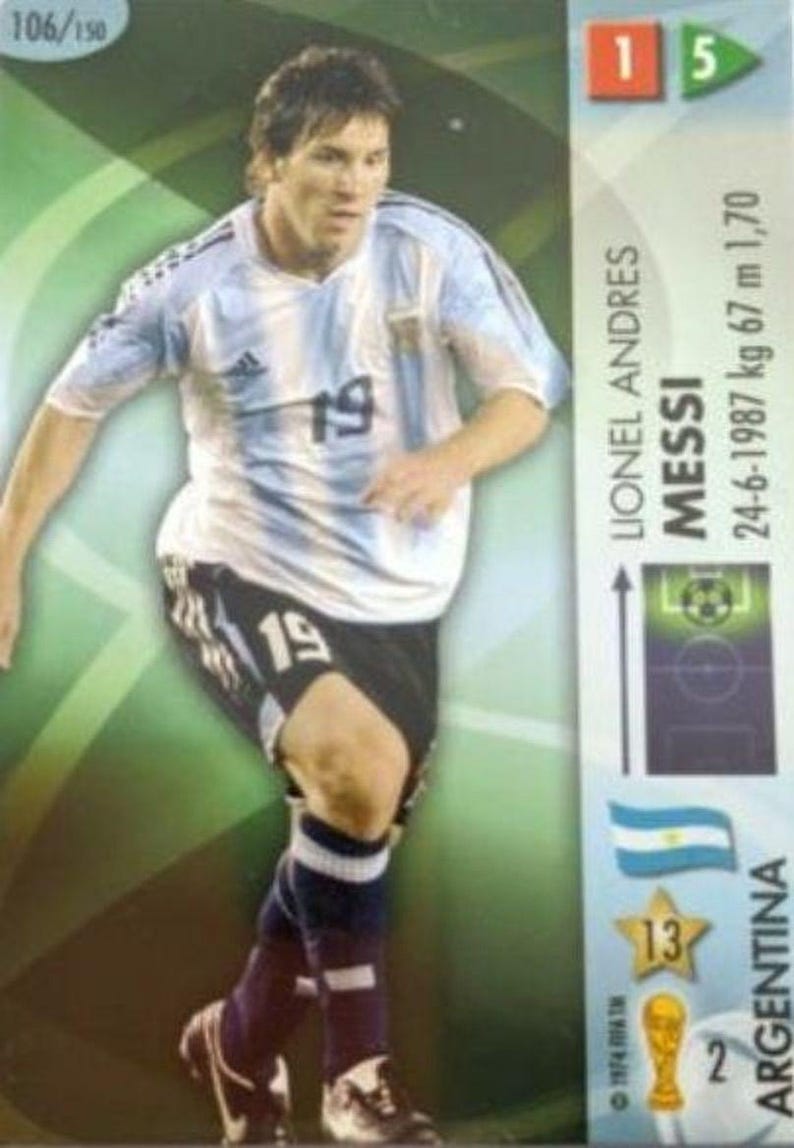 May include: A trading card featuring Lionel Messi in an Argentina soccer uniform. The card shows Messi in action, wearing a light blue and white striped jersey with the number 19. The card includes the player's name, birthdate, height (1.70 m), and weight (67 kg).