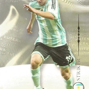 May include: A trading card featuring a soccer player in an Argentina jersey, number 10. The player is dribbling a soccer ball. The card has the Futera World Football logo and the word "Striker". The player's name "Messi" is at the bottom.