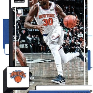 Puede incluir: Una tarjeta de intercambio de baloncesto con Julius Randle de los New York Knicks. La tarjeta es azul, negra y blanca con una foto de Randle driblando el bal&oacute;n. La tarjeta tiene el logotipo de Donruss y el texto "Julius Randle" y "Knicks".