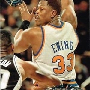 Puede incluir: Una tarjeta de baloncesto plateada y azul con Patrick Ewing, un ex jugador de la NBA, vistiendo una camiseta azul y naranja con el n&uacute;mero 33. La tarjeta tiene un dise&ntilde;o hologr&aacute;fico y una estrella plateada.