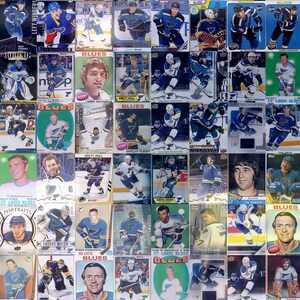 May include: A collage of trading cards featuring St. Louis Blues hockey players. The cards are arranged in a grid pattern and feature a variety of players from different eras. The cards are all in mint condition and would be a great addition to any hockey fan's collection.