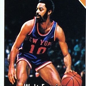 Puede incluir: Una tarjeta de colecci&oacute;n de baloncesto vintage con Walt Frazier, un jugador de los New York Knicks. La tarjeta tiene un fondo azul con el texto "Knicks" en naranja en la parte superior y "Walt Frazier" en blanco en la parte inferior. La tarjeta tambi&eacute;n incluye el texto "NBA 1st TEAM ALL-STAR" en blanco.