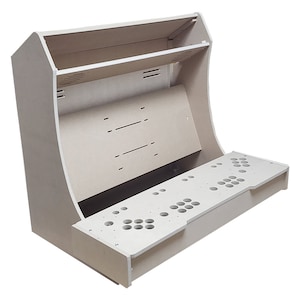 May include: A beige unfinished wooden arcade cabinet with a control panel and a top shelf. The cabinet is made of plywood and has a curved front.