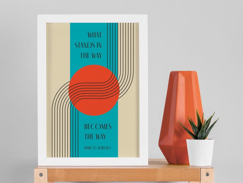May include: A framed print with a minimalist design featuring a red circle, black lines, and a turquoise background. The text reads "What stands in the way becomes the way - Marcus Aurelius".