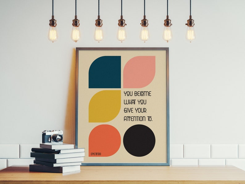 Może przedstawiać: Wydruk w ramie z geometrycznym wzorem w odcieniach niebieskiego, ż&oacute;łtego, r&oacute;żowego i czarnego. Wydruk zawiera tekst "You become what you give your attention to."