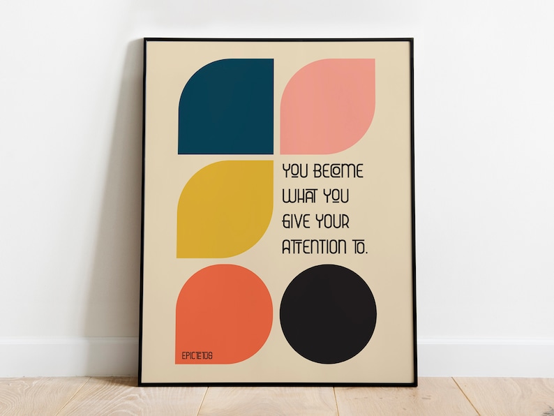 Może przedstawiać: Motivacyjny plakat z cytatem o geometrycznym wzorze, na kt&oacute;rym znajdują się cztery kolorowe kształty: p&oacute;łkole w kolorze ciemnoniebieskim, p&oacute;łkole w kolorze r&oacute;żowym, kształt liścia w kolorze ż&oacute;łtym i kształt liścia w kolorze pomarańczowym. Cytat brzmi: "Stajesz się tym, na czym skupiasz swoją uwagę." Plakat jest oprawiony w czarną ramę i zawiera napis "Epictetus" w lewym dolnym rogu.