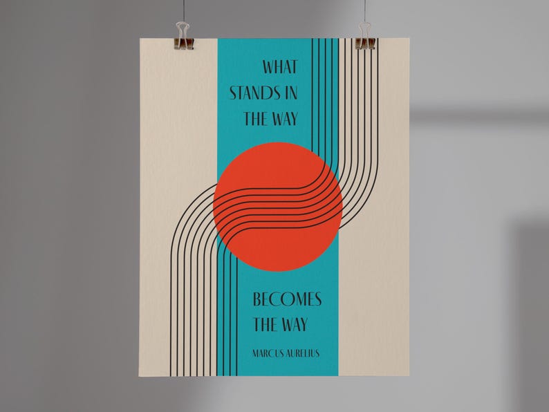 May include: A motivational quote poster with a teal background and a red circle with black lines. The quote reads "What stands in the way becomes the way" by Marcus Aurelius.