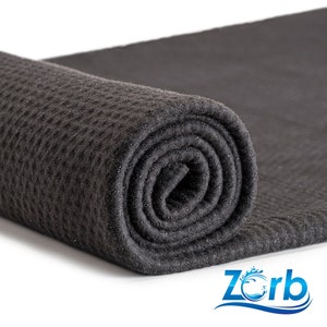 May include: A black waffle weave microfiber towel rolled up. The towel is made of a soft, absorbent material and is perfect for drying your car or other surfaces.