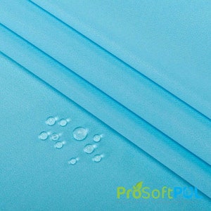 May include: Close-up of a light blue fabric with water droplets on the surface. The fabric is smooth and has a subtle sheen. The droplets are round and clear, and they are scattered across the fabric.