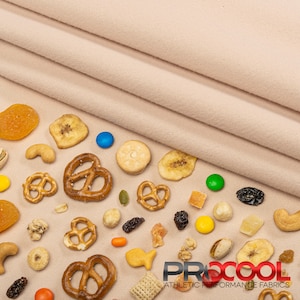 May include: A beige fabric background with various snacks scattered across it. The snacks include pretzels, dried fruit, nuts, and candies. The logo "PROCOOL ATHLETIC PERFORMANCE FABRICS" is visible in the bottom right corner.