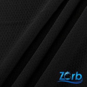 Puede incluir: Tela negra con tejido texturizado. La tela est&aacute; doblada en diagonal. El logotipo de Zorb est&aacute; en la esquina inferior derecha de la imagen.