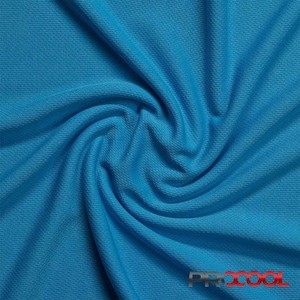May include: Close-up of a bright blue fabric with a textured, waffle-like pattern. The fabric is folded and twisted, showing its flexibility and drape.