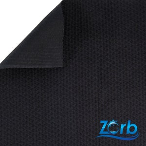 Puede incluir: Tela negra con una superficie texturizada. La tela est&aacute; doblada sobre s&iacute; misma, revelando un reverso negro liso. La tela tiene un logotipo "Zorb" en azul con un dise&ntilde;o de onda.
