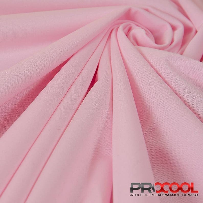 May include: A close-up of a soft, pink fabric with a subtle texture. The fabric is folded and draped, showcasing its drape and flexibility. The fabric is labeled "PROCOOL ATHLETIC PERFORMANCE FABRICS".