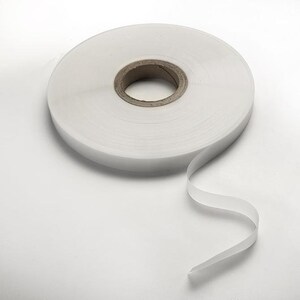 May include: A roll of white heat seal tape, a type of adhesive tape used for sealing bags and pouches.