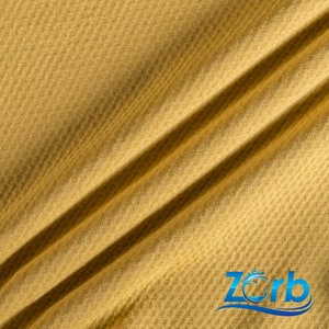 May include: A close-up of a yellow waffle knit fabric. The fabric has a textured surface and is folded in two places.