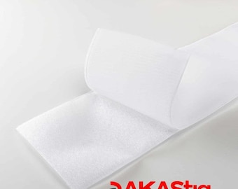 May include: White hook and loop tape, also known as Velcro, is shown folded over on itself. The tape is made of a soft, fuzzy material. The text "AKASTIQ STRONG LOOP FABRICS" is visible in red at the bottom of the image.