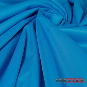 May include: A close-up of a bright blue fabric with a smooth texture. The fabric is folded and draped, showcasing its soft and flowing nature.