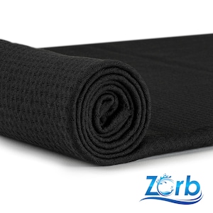 Puede incluir: Una toalla de microfibra negra enrollada. La toalla está hecha de un material suave y absorbente, ideal para secar las manos, la cara o el cabello.