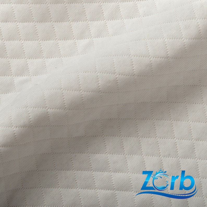 May include: White quilted fabric with a subtle diamond pattern. The fabric is soft and smooth to the touch.