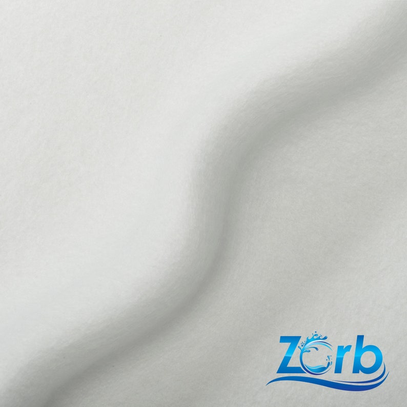 May include: White fabric with a slight wave pattern. The fabric is smooth and soft. The word "Zorb" is printed in blue with a wave design.