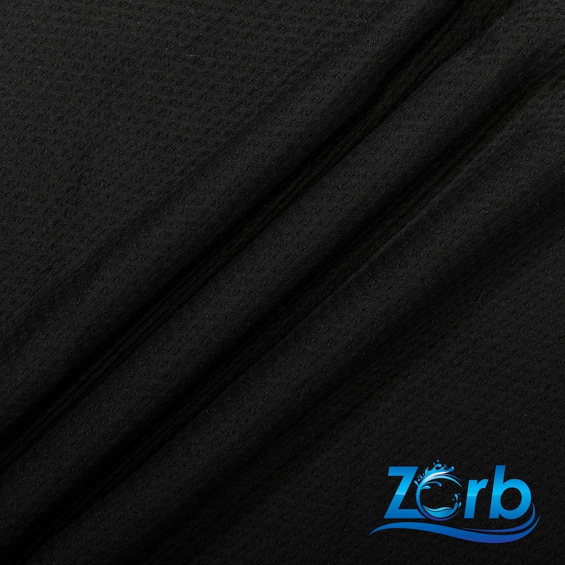 May include: Black fabric with a textured surface. The fabric is folded in half, creating a diagonal line. The Zorb logo is visible in the bottom right corner.
