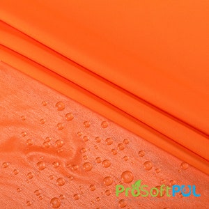 May include: Orange fabric with water droplets on the surface. The fabric is smooth and has a slight sheen. The droplets are clear and round. The fabric is folded in half, with the top layer of fabric covering the bottom layer. The text "ProSoftPUL" is visible in the lower right corner of the image.