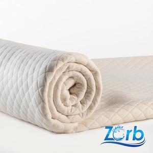 Puede incluir: Un protector de colchón acolchado blanco enrollado con un patrón de diamante. El protector de colchón está hecho por Zorb.