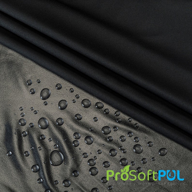 May include: Black fabric with water droplets on the surface. The fabric is water-resistant and has a smooth texture.